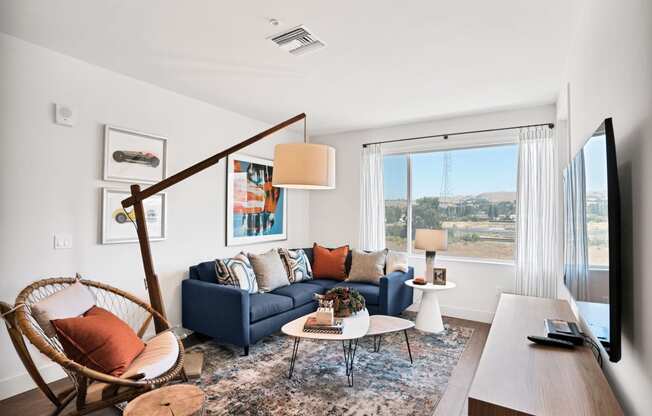 a living room with a blue couch and a large window