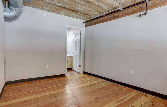 an empty room with a wooden floor and white walls