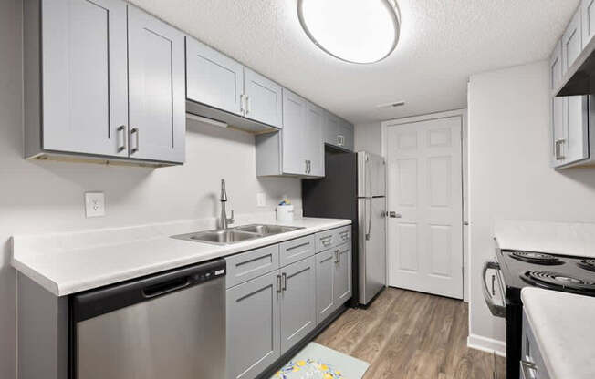 A kitchen with a white counter top and stainless steel appliances.