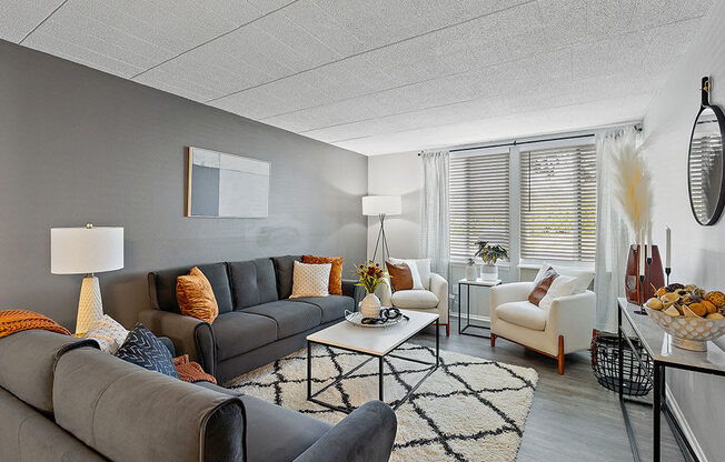 A living room with a grey couch, a white armchair, and a coffee table.