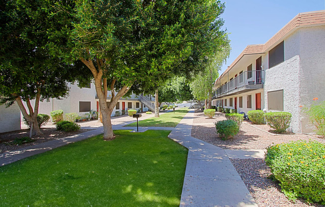 a walkway between two buildings at the whispering winds apartments in pearland, tx