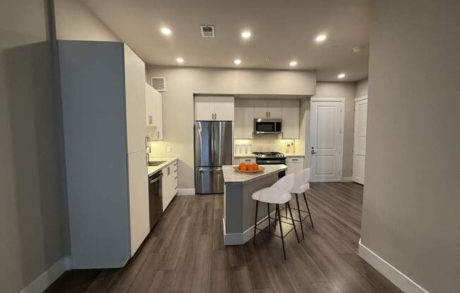 A kitchen with a table and chairs in the middle of the room.