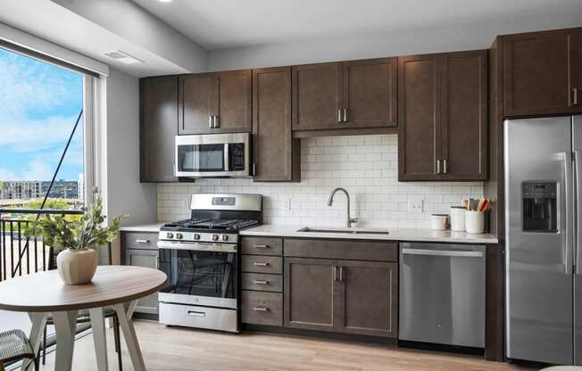 a kitchen with dark wood cabinets and stainless steel appliances