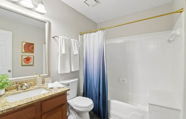 A bathroom with a toilet, sink, and shower.