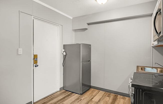 a kitchen with a refrigerator and a stove and a door