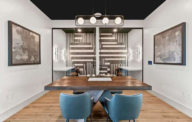 A modern dining room with a wooden table and blue chairs.