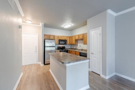 A kitchen with white cabinets and a wooden island.