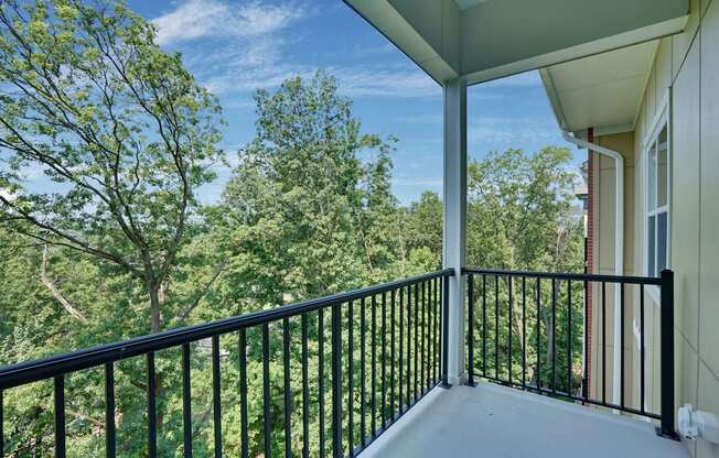a balcony with a view of trees and a blue sky