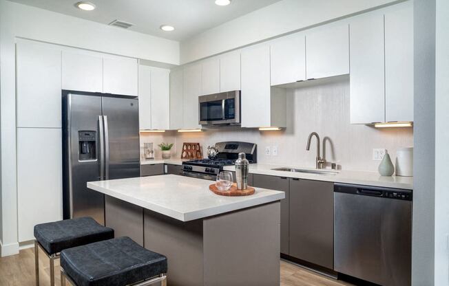 A modern kitchen with a stainless steel refrigerator and a white countertop.