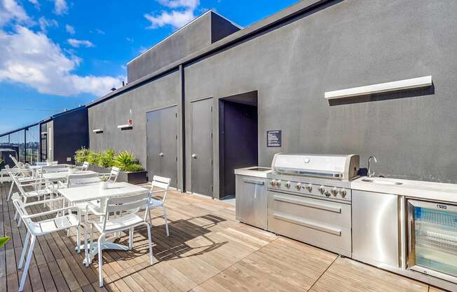 A patio with a grill and chairs.