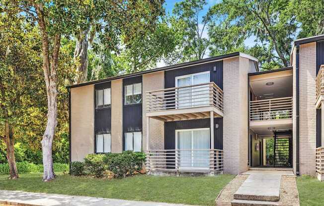 A modern two-story apartment building with balconies and a front door entrance.