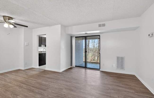 A room with a sliding glass door leading to a backyard.