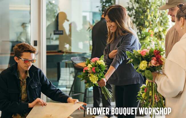 A group of people are gathered around a table with a man pointing at a piece of paper.
