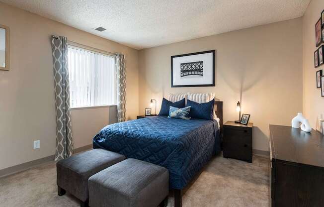 a bedroom with a bed and a dresser and a window