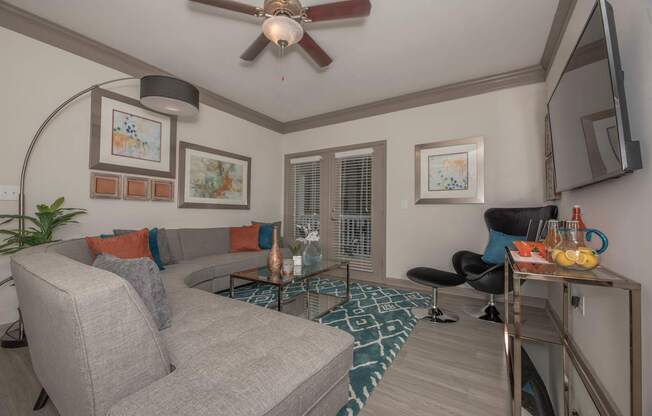 a living room with a couch and a ceiling fan