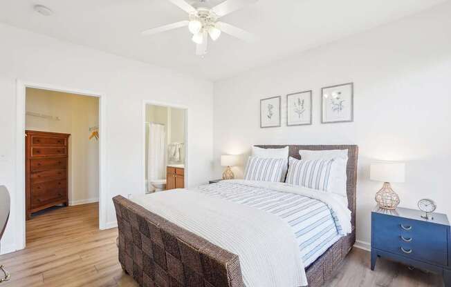 A bedroom with a large bed and a ceiling fan.