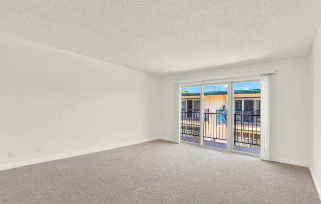 an empty living room with a door to a balcony at Camino de Oro Apartments, Torrance, CA, 90505