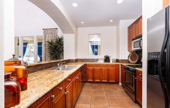 A kitchen with brown cabinets and a granite countertop.