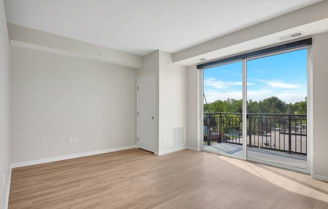 a bedroom with a sliding glass door and hardwood floors