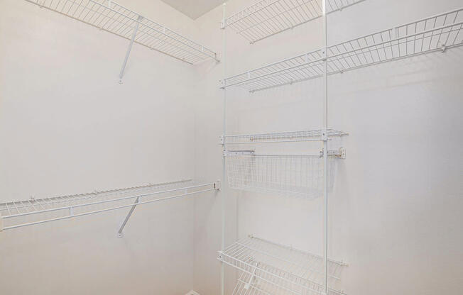 A walk-in closet with wardrobe organizers at West Hampton Park Apartments in Elkhorn, NE 68022