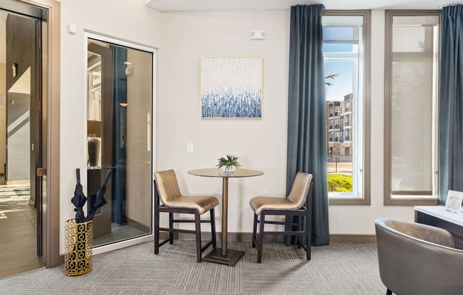 A room with a table and chairs and a painting on the wall.