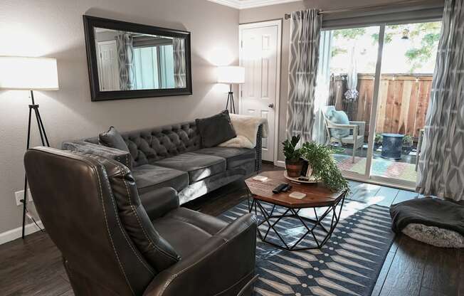 a living room with a couch and chair in front of a sliding glass door