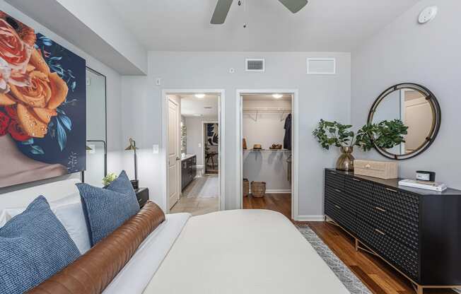 a bedroom with a bed and a dresser and a bathroom