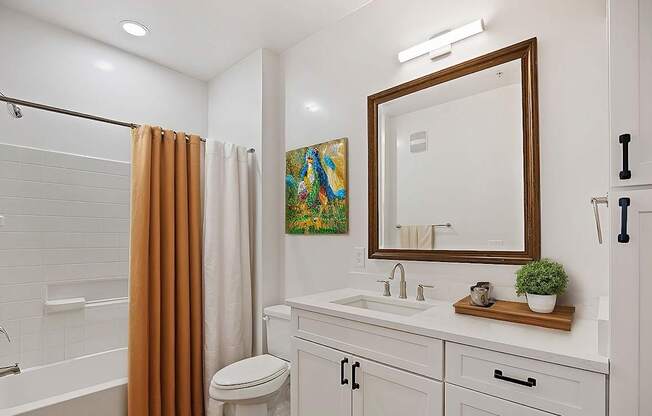 A bathroom with a white toilet, sink, and a brown shower curtain.