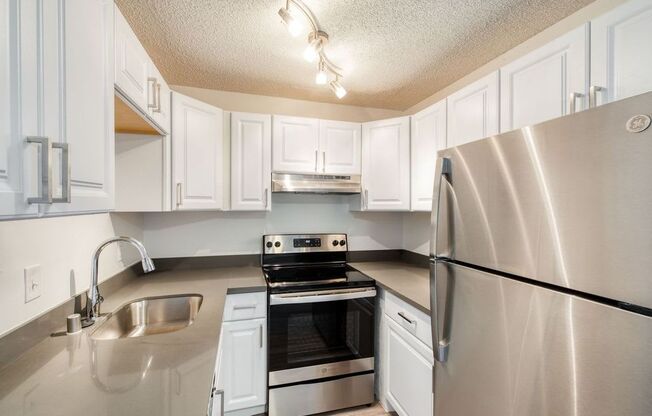 a kitchen with white cabinets and stainless steel appliances