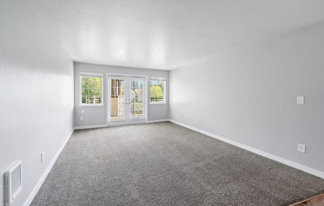 an empty living room with a door to a patio