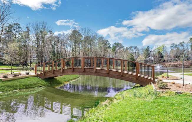 A bridge over a pond in a park.