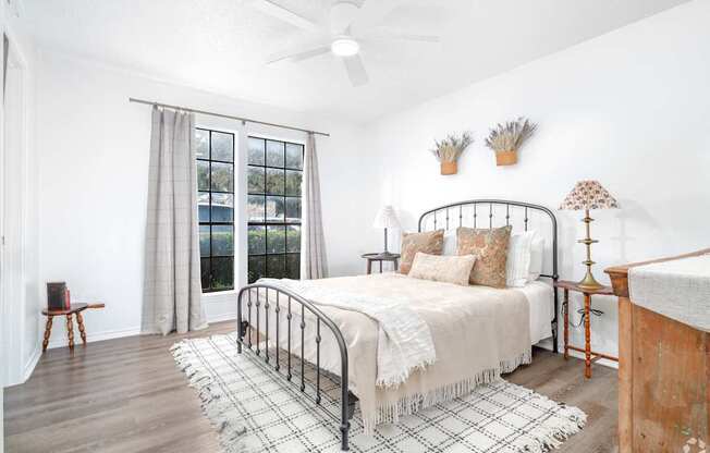 A bedroom with a bed, a chair, and a window with curtains.