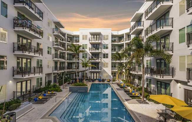 A swimming pool is surrounded by apartment buildings.