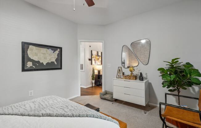 a bedroom with a bed and a dresser and a map on the wall