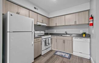 A kitchen with white appliances and wooden cabinets.
