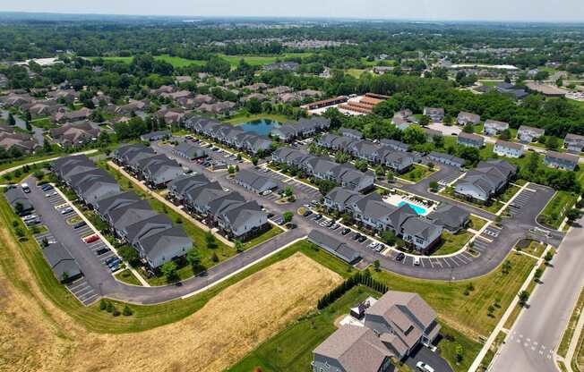 A bird's eye view of a residential area with houses and a swimming pool.