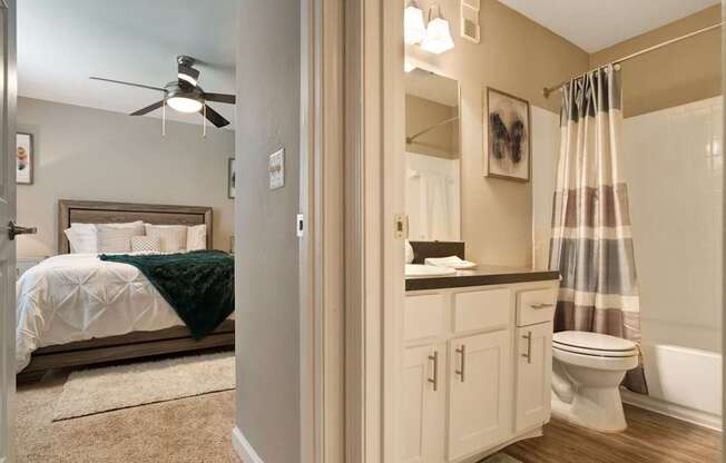 A bedroom with a bed, a toilet, and a shower.