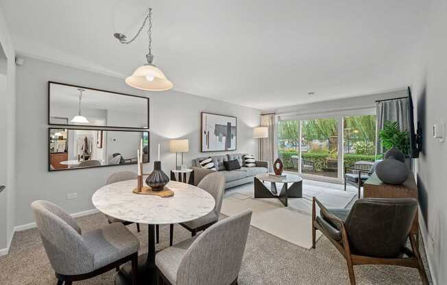 A modern dining room with a round table and grey chairs.
