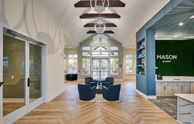 a lobby with blue chairs and a green wall and glass doors