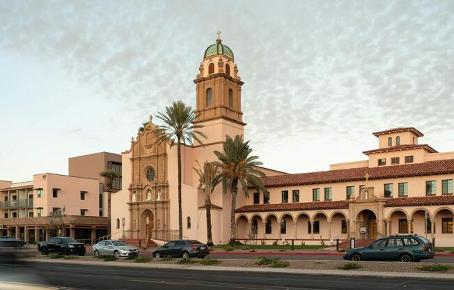 a large building with a clock on the side of a road