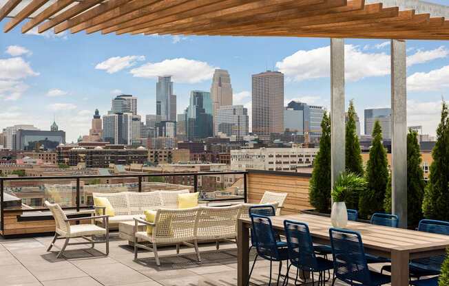 A patio with chairs and a table overlooking a city skyline.