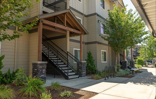 A building with a wooden porch and a staircase leading to the entrance at Forestplace Apartment Homes, Forest Grove, OR
