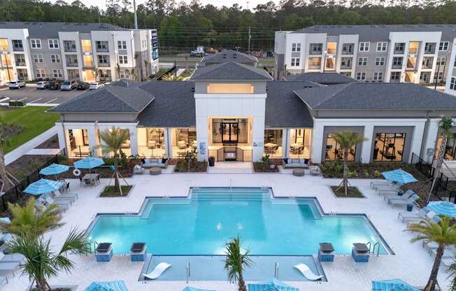 A large white building with a pool in front.