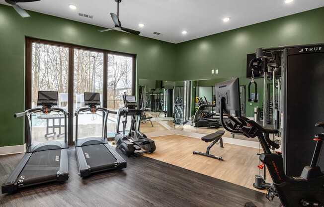 A well-equipped gym with treadmills, exercise bikes, and weight machines.