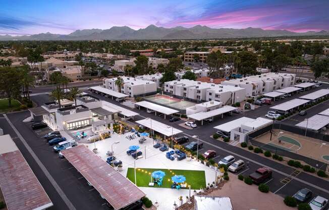 an aerial view of the community at sunset with mountains in the background