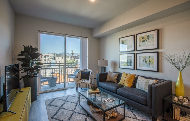 Apartments for Rent in Oakland CA - Open Space Living Room with Stylish Interiors and Hardwood Floor Featuring Sliding Door to Balcony