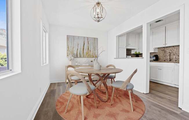 A dining room with a white table and chairs.