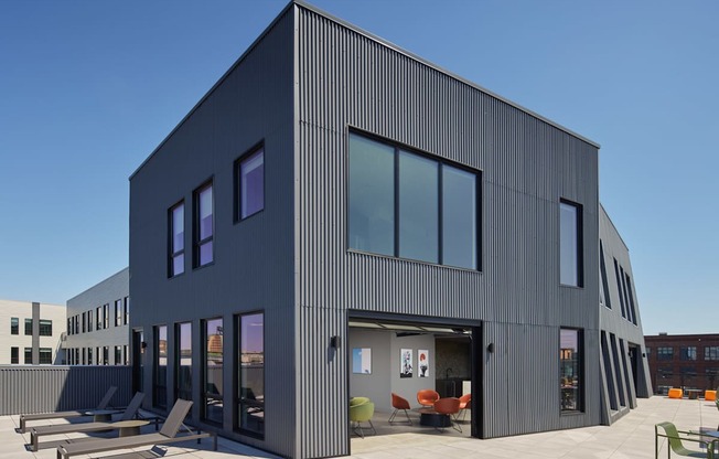 A modern building with a black exterior and large windows.