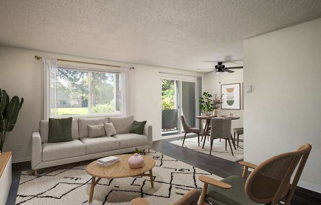 A living room with a couch, a chair, a table, and a ceiling fan.