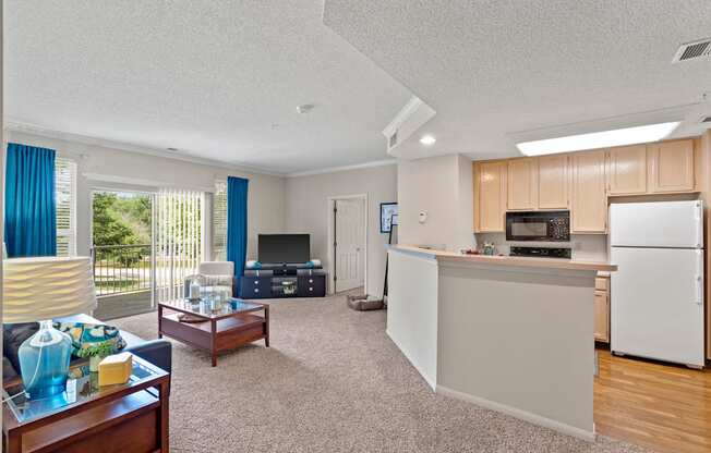 a living room with a kitchen in the background
